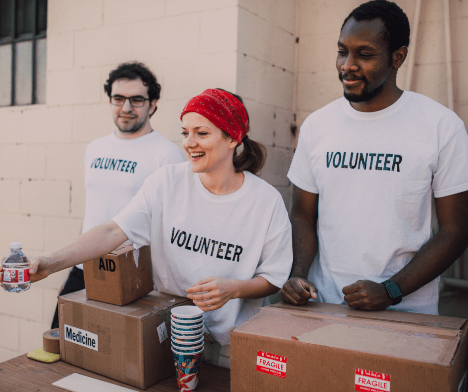 three people volunteering at a food drive